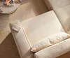 A close-up overhead view of a beige corduroy sofa with a book on the armrest and a coffee table with books in the background. Produktbild-Vorschau