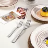 A table setting with plates, forks, and decorative cards. Produktbild-Vorschau