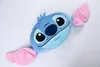 A blue Stitch plush toy with pink ears is lying on a white surface. Voir les images du produit