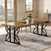 A dining room scene with a wooden dining table and chairs, set with a vase of flowers and a bowl of green apples. Produktbild-Vorschau