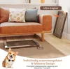A dog is sitting in front of a couch, with a folded wooden pet gate on the floor. Podgląd zdjęcia produktu