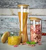 Three glass storage jars filled with pasta and spaghetti, with a wooden background. Produktbild-Vorschau