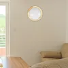 A ceiling light fixture with a wooden frame is mounted on a light beige wall in a room with a sofa and a wooden table. Produktbild-Vorschau