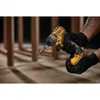 A person wearing black gloves is holding a yellow and black DeWalt cordless drill. Produktbild-Vorschau