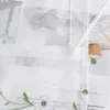 A close-up of a sheer white curtain with embroidered daisies and text visible through it. Produktbild-Vorschau