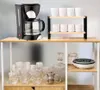 A coffee maker and glassware are displayed on shelves. Anteprima dell’immagine prodotto