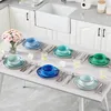 A dining table set with plates, bowls, and cutlery, arranged for a meal. Produktbild-Vorschau