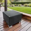 A black rattan coffee table with a glass top sits on a wooden deck in a garden setting. Produktbild-Vorschau