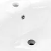 A close-up view of a white ceramic sink with two drain holes. Podgląd zdjęcia produktu