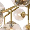 Close-up view of a gold chandelier with multiple glass globes. Náhľad obrázku produktu