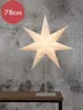 A lit star-shaped lamp on a stand, placed on a wooden table against a textured gray wall. Produktbild-Vorschau