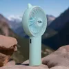 A portable fan is displayed on rocks with mountains in the background. Produktbild-Vorschau