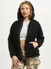 A woman wearing a black hooded fleece jacket and camouflage pants. Produktbild-Vorschau