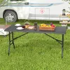 A folding table set up on grass in front of a camper van, with food and drinks on the table. Anteprima dell’immagine prodotto