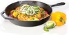A cast iron skillet filled with food, next to a yellow bell pepper and lime wedges. Voir les images du produit