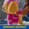 A child's hand is shown attaching a pink backpack to a plush toy dog. Podgląd zdjęcia produktu