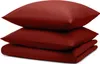 A stack of dark red bedding items, including two pillows and a folded duvet or comforter, is presented against a white background.