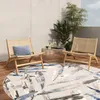 An outdoor patio scene with two chairs, a coffee table, plants, and a round rug. Náhľad obrázku produktu