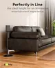 A dark leather sofa in a living room with a speaker stand next to it. Náhled obrázku produktu