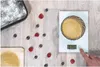 A digital kitchen scale with food ingredients scattered around it. Anteprima dell’immagine prodotto