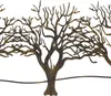A close-up view of a metal wall decoration featuring stylized trees. Produktbild-Vorschau
