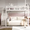 A white loft bed with stairs and a sofa underneath, set in a child's bedroom with pink and grey decor. Náhľad obrázku produktu