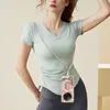 A woman wearing athletic clothing is posing with a phone case that has a lanyard attached. Náhled obrázku produktu