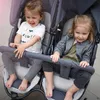 Two young children sitting in a double stroller. Produktbild-Vorschau