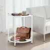 A white side table with items on it, next to a white sofa. Voir les images du produit
