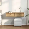 A floating shelf with two drawers is mounted on a white wall above a white ottoman. A bed is partially visible on the left, and a plant is on the right. Náhled obrázku produktu