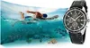 A man swimming underwater with a watch next to him. Produktbild-Vorschau