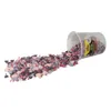 A container of heart-shaped sprinkles is tipped over, spilling its contents onto a white surface. Produktbild-Vorschau