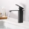A black waterfall faucet in a bathroom sink with water flowing. Náhled obrázku produktu