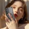 A woman is holding a phone case in front of her face. Anteprima dell’immagine prodotto