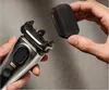 A person is holding a Braun Series 9 Pro+ electric shaver and a cleaning brush attachment. Produktbild-Vorschau