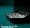 Close-up of a coffee machine's drip tray, made of stainless steel, with text overlaid. Produktbild-Vorschau