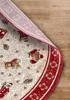 A close-up view of a round Christmas-themed rug, partially lifted to reveal the wooden floor underneath. Podgląd zdjęcia produktu