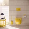 A modern bathroom with yellow accents, featuring a toilet, toilet brush, and toilet paper holder. Anteprima dell’immagine prodotto