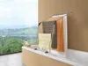 A metal clothes drying rack is placed over a bathtub, with towels hanging on it. The background shows a scenic view of hills and a lake. Voir les images du produit