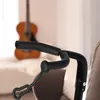 A close-up shot of a black guitar stand with a guitar in the background. Náhľad obrázku produktu