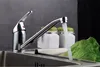 A kitchen faucet with water running into a sink, with two jars and lettuce in the background. Produktbild-Vorschau