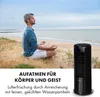 A man meditating on a beach with a tower fan. Produktbild-Vorschau
