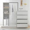A white wardrobe set with a hanging rack and a chest of drawers, set against a white wall with subtle decorative molding. Anteprima dell’immagine prodotto