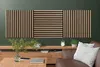 A living room setting with acoustic panels mounted on a green wall above a wooden media console. Anteprima dell’immagine prodotto