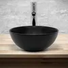 A black ceramic vessel sink with a chrome faucet is shown on a wooden countertop against a concrete wall. Náhled obrázku produktu
