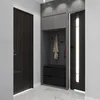 A modern entryway with a dark wood door on the left, a built-in gray cabinet with a bench and drawers, and a black door with a vertical light strip on the right. The floor is white marble. Produktbild-Vorschau