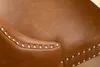 A close-up view of a brown leather chair with silver studs. Produktbild-Vorschau