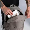 A person is putting a notebook into a PUMA backpack. Anteprima dell’immagine prodotto