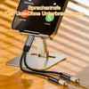 A USB-C audio and charging splitter is connected to a smartphone, which is mounted on a stand. The phone screen displays an incoming call interface. Produktbild-Vorschau