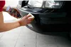 A person is applying a cleaning product to a car bumper. Produktbild-Vorschau